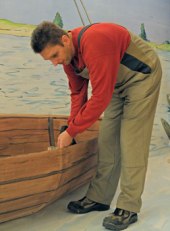 Unser  Haustechniker Rainer Kr�lls "beim Bootsbau" vor einer Gro�illustration des mittelalterlichen Duisburger Hafens. Foto KSM 